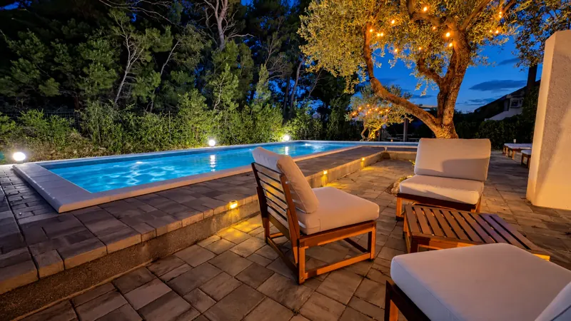 Evening pool terrace beneath string lights