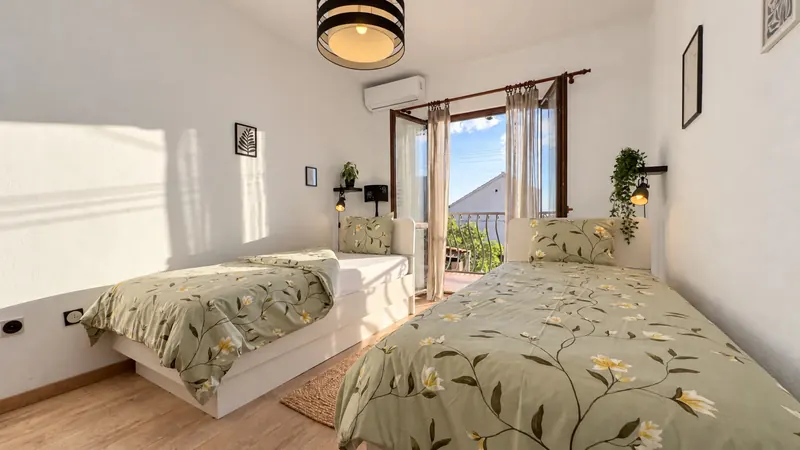 Bedroom 1 with two beds and balcony doors